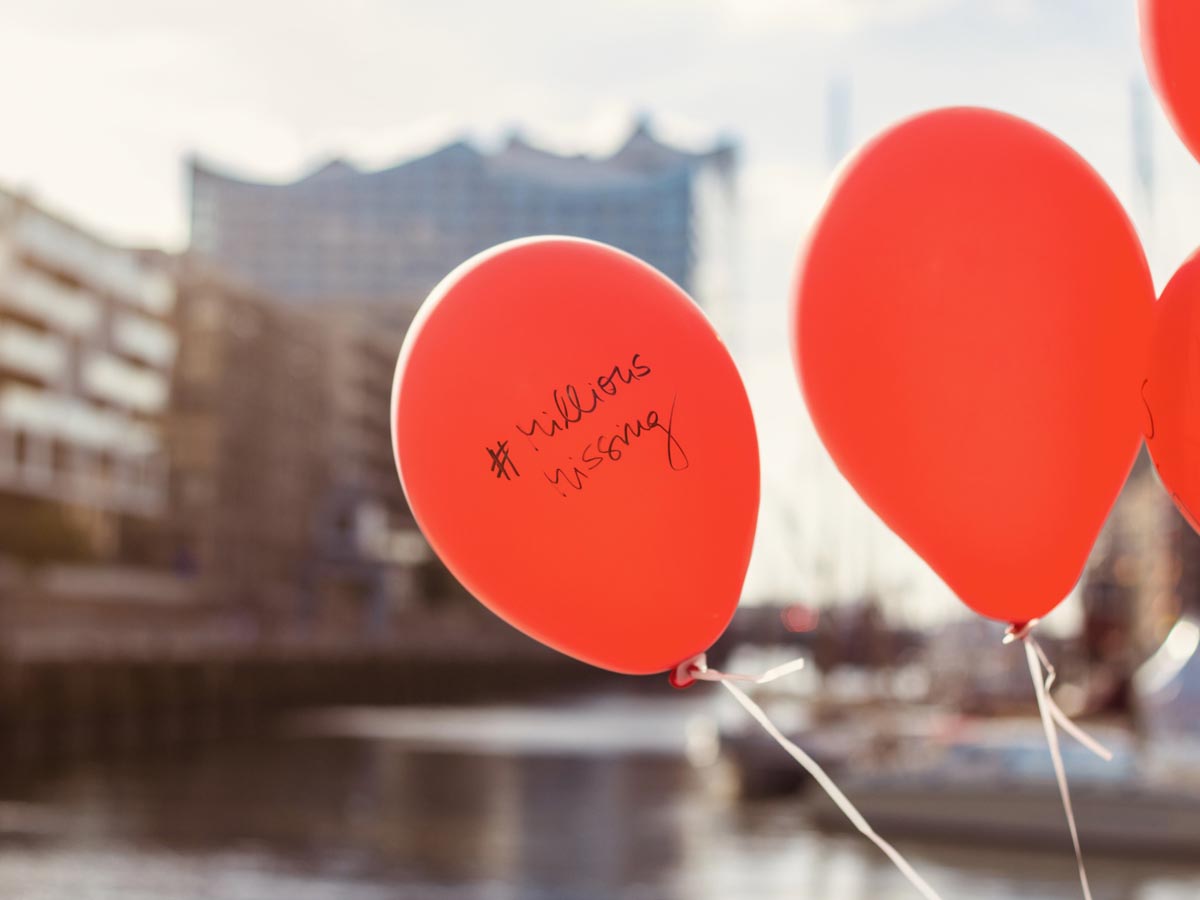 Zwei rote Ballons mit der Aufschrift #MillionsMissing